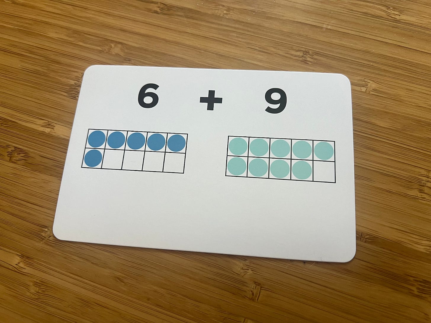 An addition by heart card for 6 + 9. You see a ten frame with six circles in it and a ten frame with 9 circles in it.