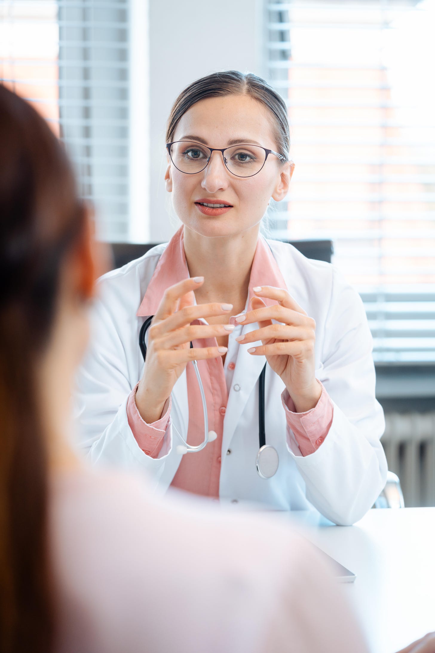 Young female doctor talking to a female patient