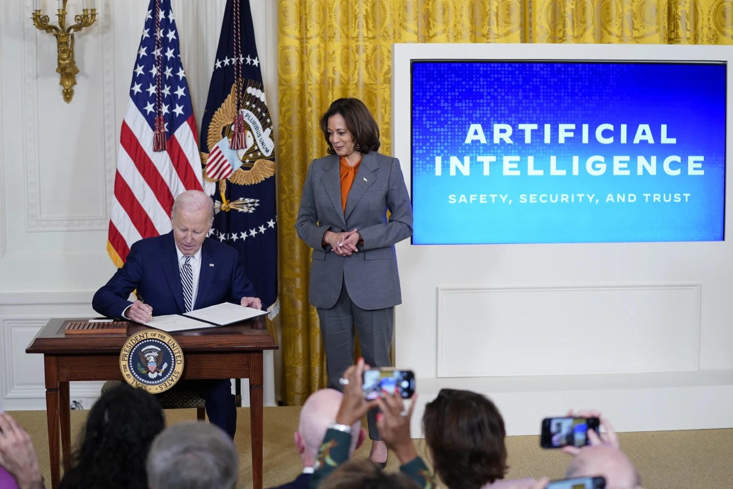 President Joe Biden signs and executive on artificial intelligence in the East Room of the White House, Monday, Oct. 29, 2023, in Washington. Vice President Kamala Harris looks on at right. (AP Photo/Evan Vucci)