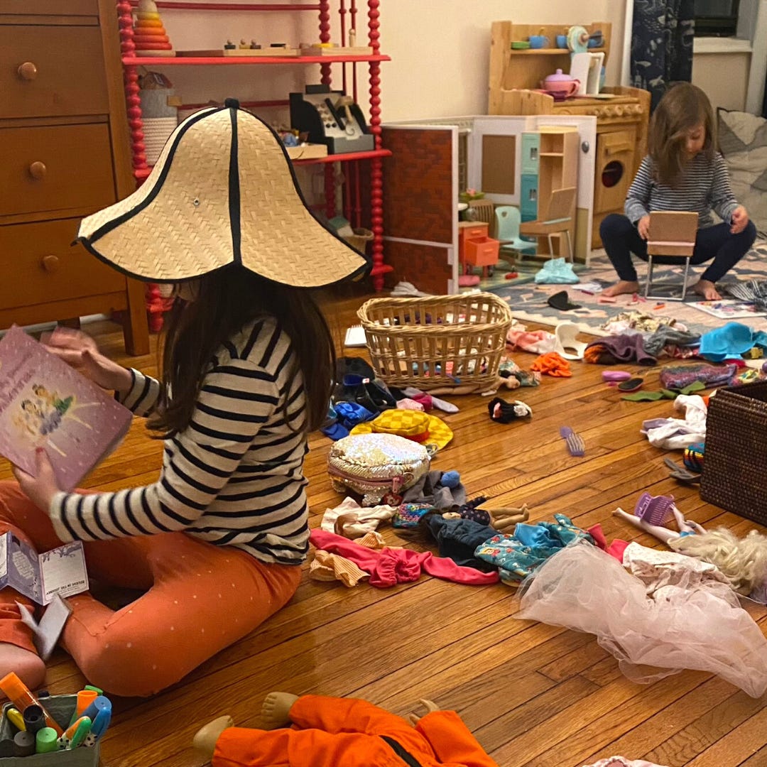 Two children engaged in play in a messy room.