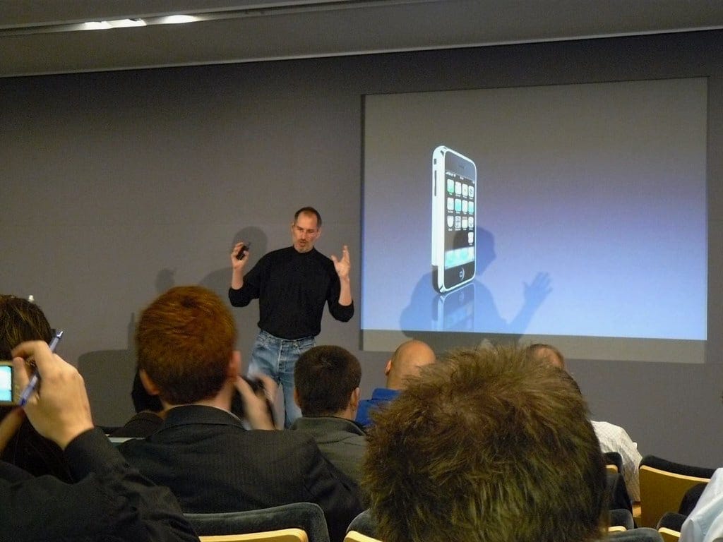 Steve Jobs announces the iPhone on O2 in the Theater at Apple Regent Street. A photo of an iPhone is displayed on the Theater screen.