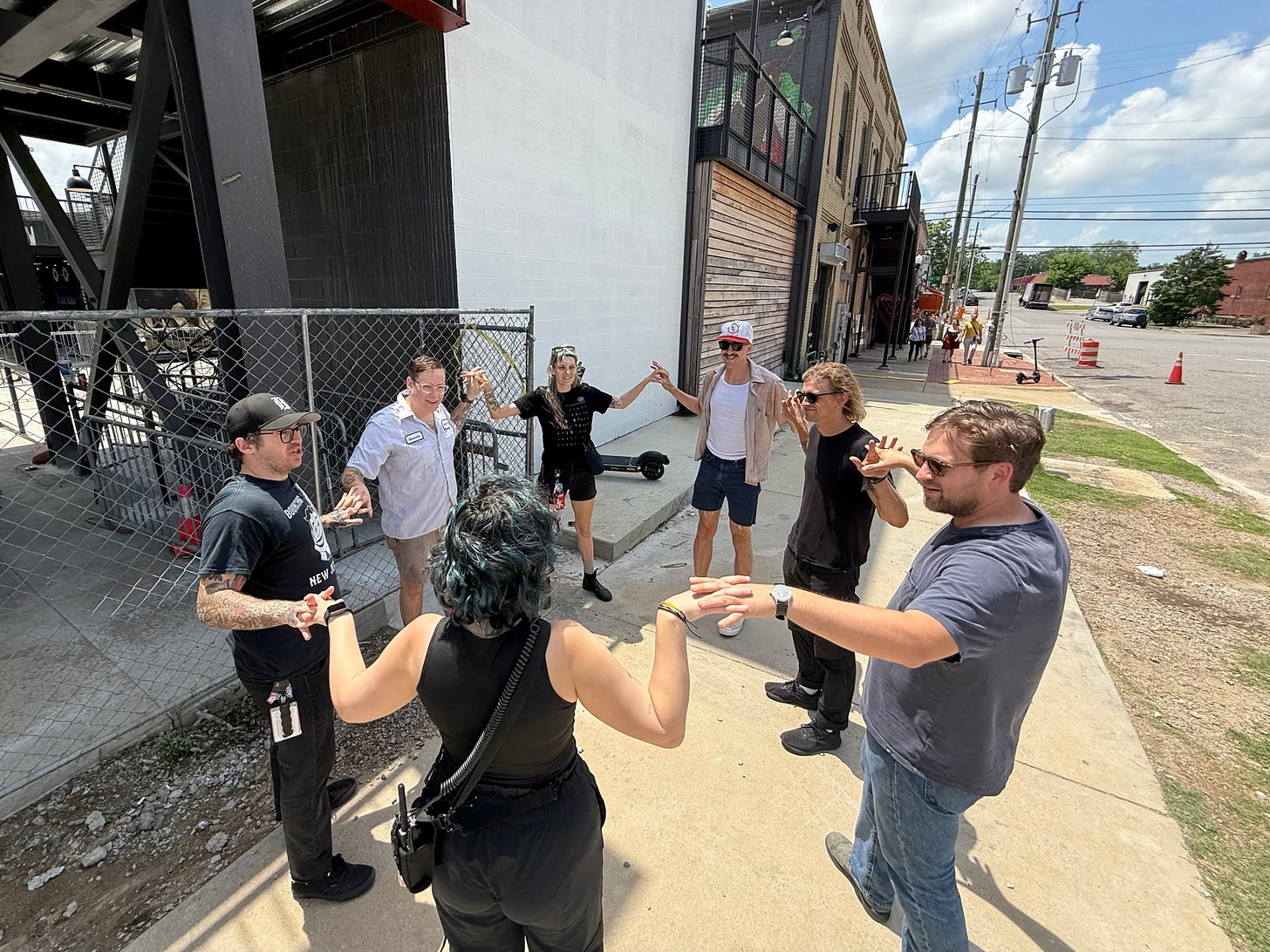 Crew members hold hands on the sidewalk in Birmingham.