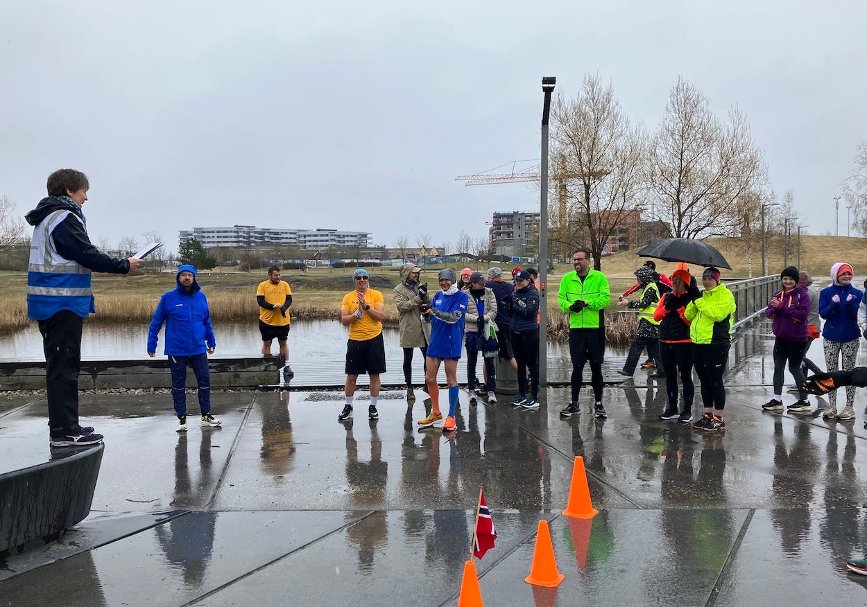 Briefing pre-run on concrete, with development in the background marked by a crane