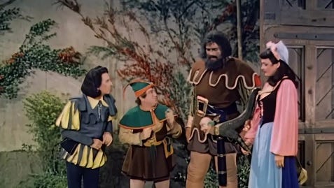 Bud Abbott, Lou Costello, Buddy Baer and Dorothy Ford in Jack and the Beanstalk. Abbott and Costello are prisoners of the Giant and his housekeeper is stood beside him.