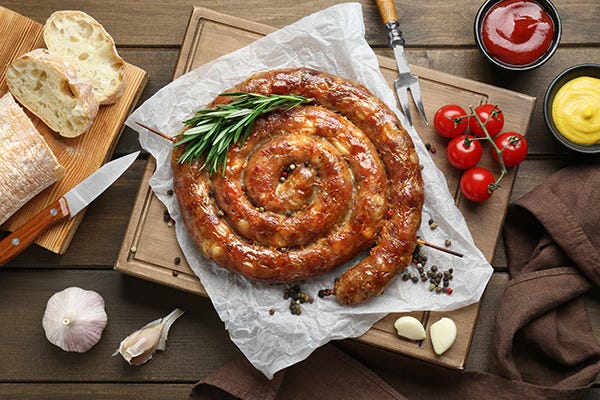 Food photo of cooked sausage ring and garnishes