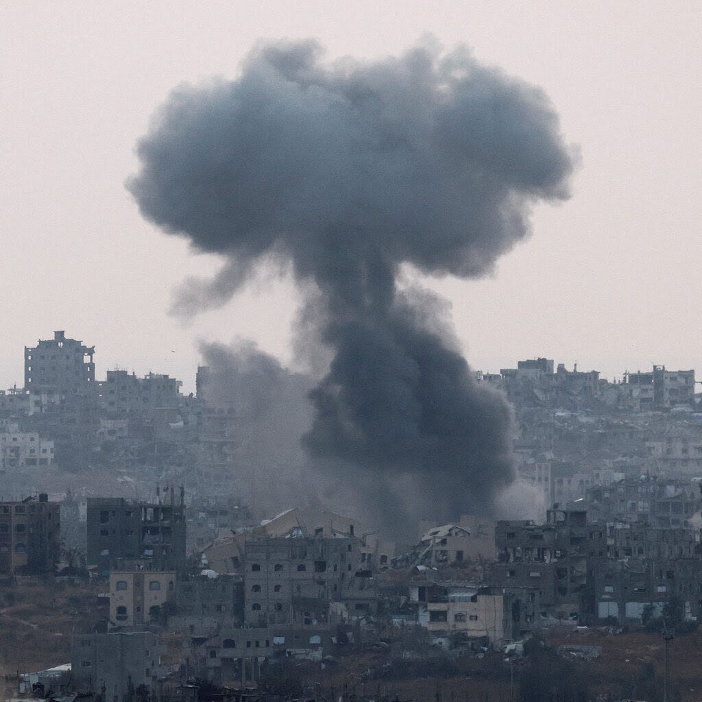 A plume of dark smoke rises over a Gaza neighborhood in ruins. 