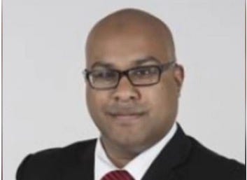 A person in a suit and tie

Description automatically generated