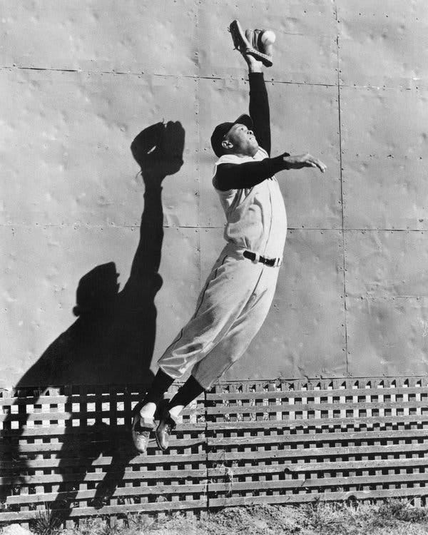 Willie Mays leaps to catch a ball.