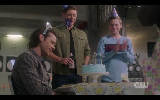 Dean Jack giving Sam Winchester a birthday cake with hat SPN