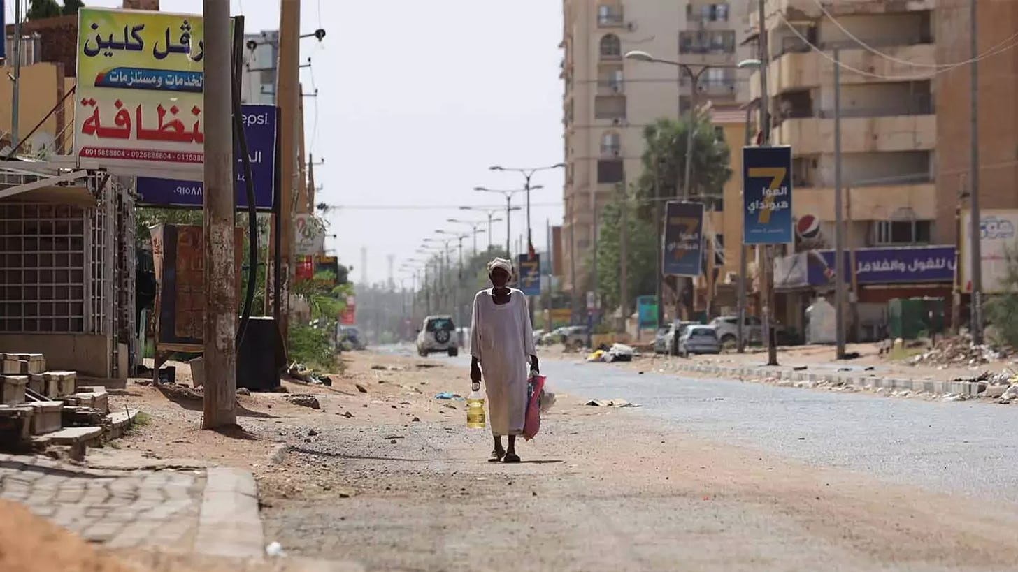 A man trapped by fighting in April 2023 walks towards his home in Khartoum. Residents of the devastated capital are experiencing deep hunger as war stretches into a second year.