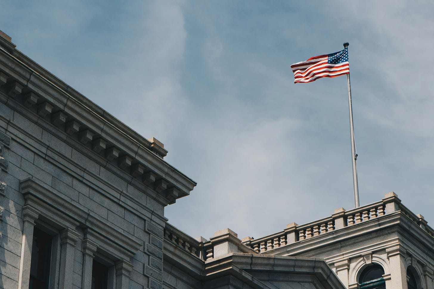 Photo of American flag flying above federal courthouse