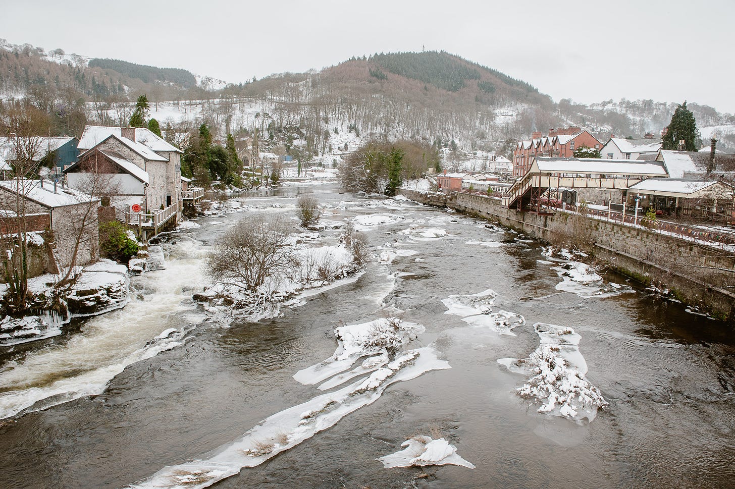 A river runs through a snowy Welsh town.