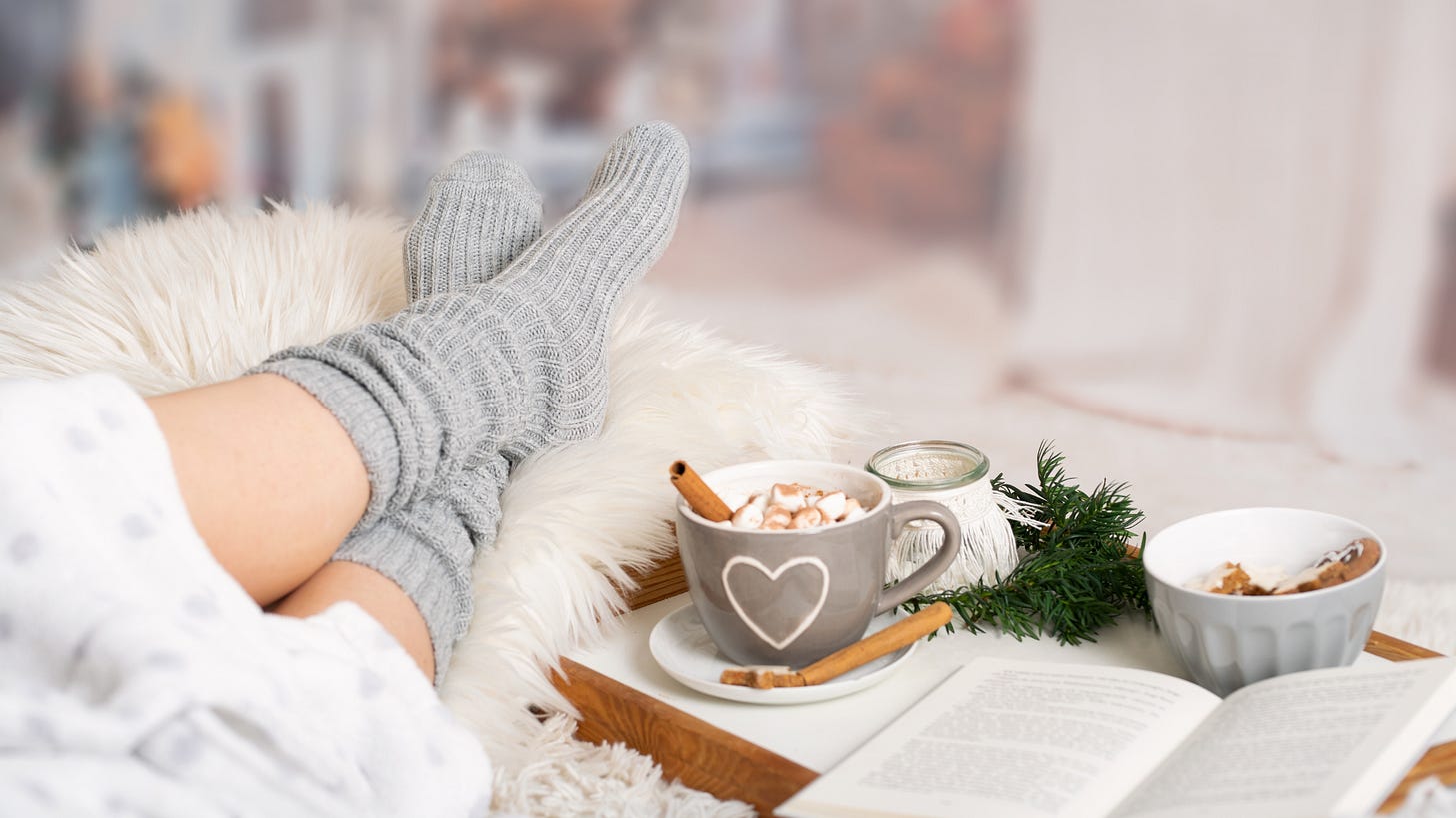 woman wearing cozy grey socks and enjoying a lazy day with coffee