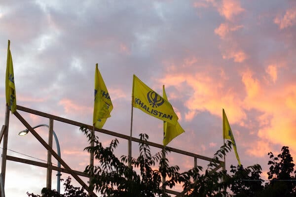 Yellow flags bearing the word “KHALISTAN” in all capital letters flutter against an evening sky.