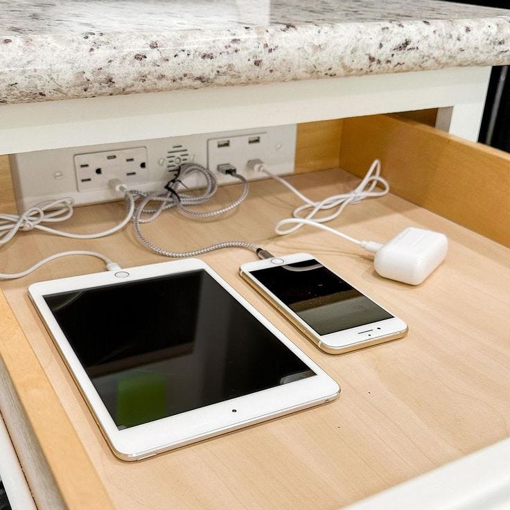 This may contain: two tablet computers sitting on top of a wooden table next to an outlet plugged in This may contain: two tablet computers sitting on top of a wooden table next to an outlet plugged in