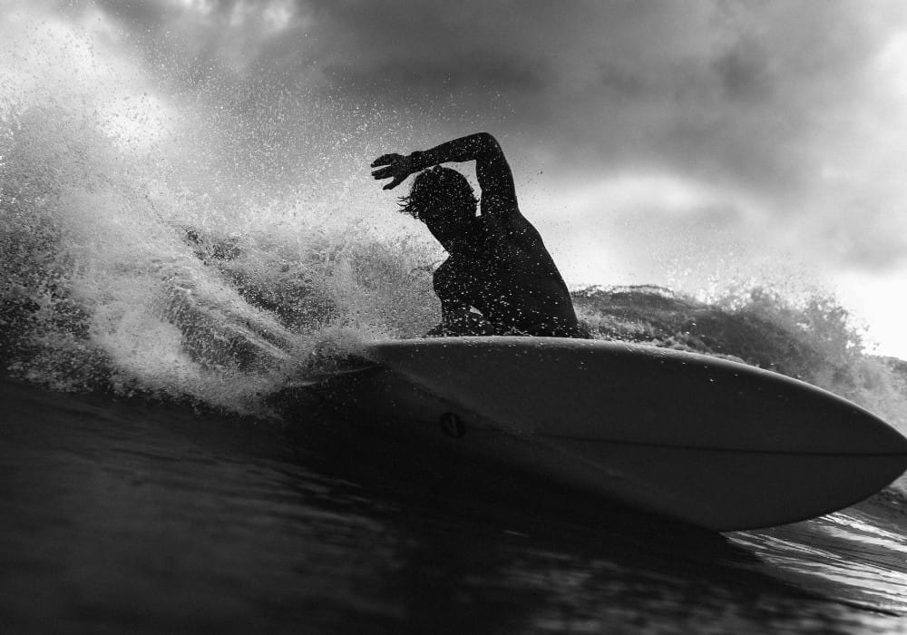 Black and white image of a surfer showing what it's like to live life in high vibration