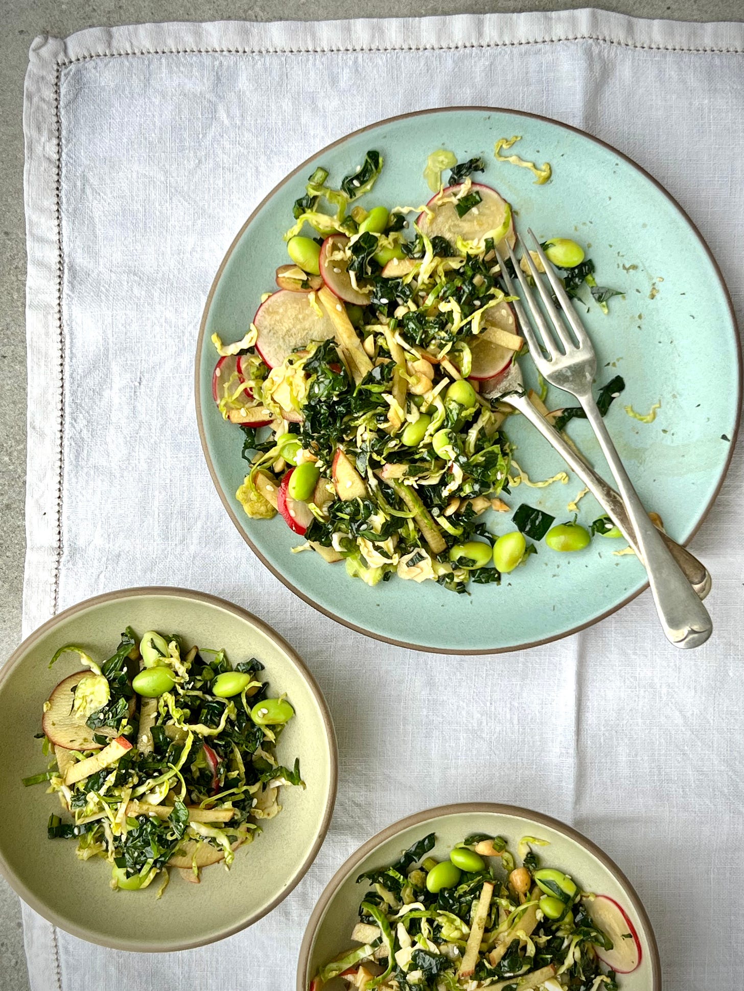 plates and bowls messily filled with miso kale salad