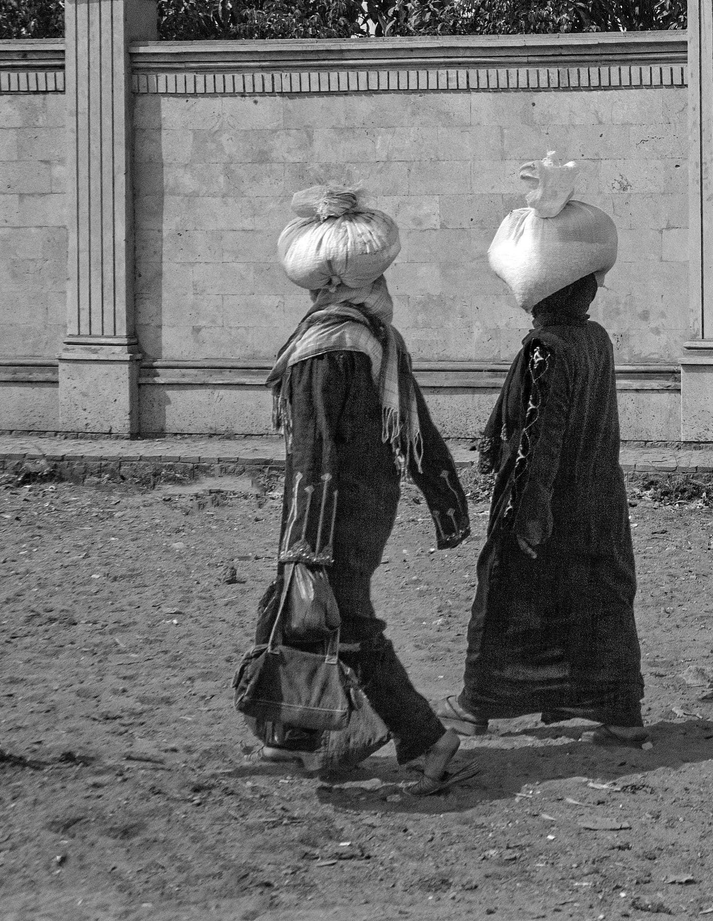 Two woman with a bundle on their heads.