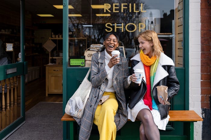 Two women laughing outside a store