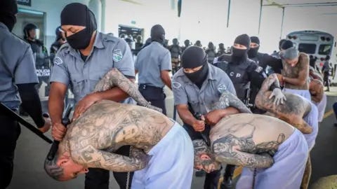 Reuters Prison agents guard gang members as they are processed at their arrival after 2000 gang members were transferred to the Terrorism Confinement Center,