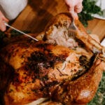Someone is cutting the Thanksgiving turkey (Claudio Schwarz/unsplash).