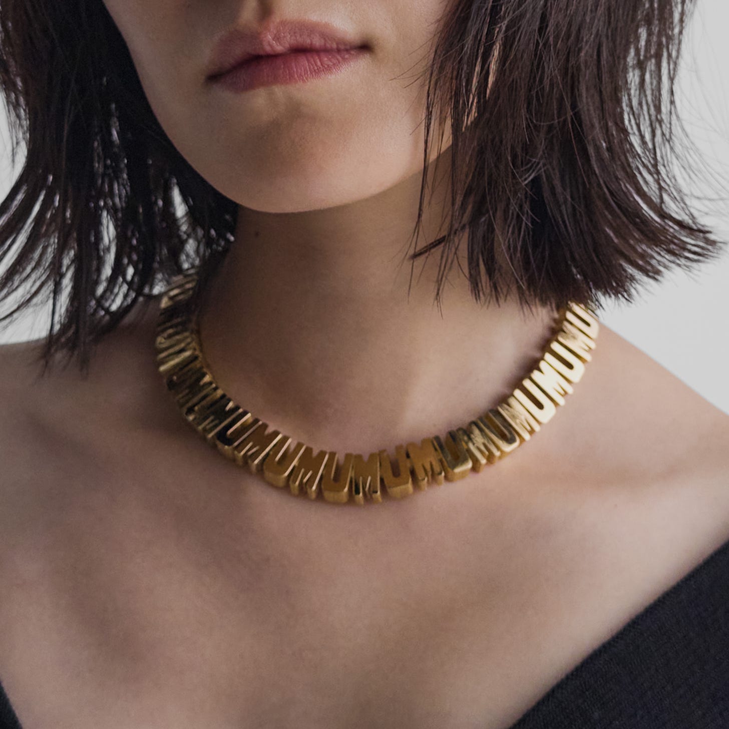 Model wearing mum necklace in gold-plated sterling silver.