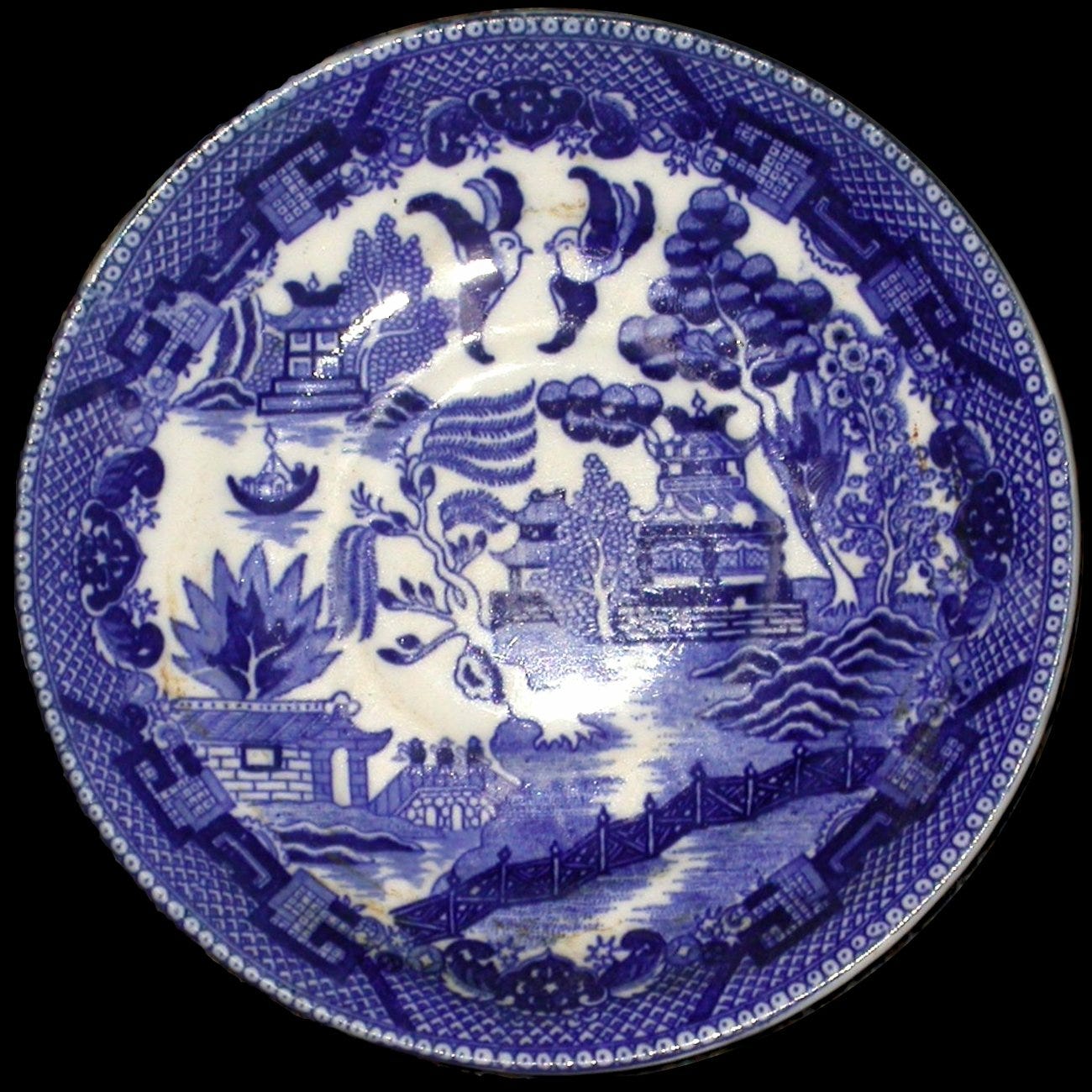 Plate with fanciful scenes of trees, pagodas, people in blue and white