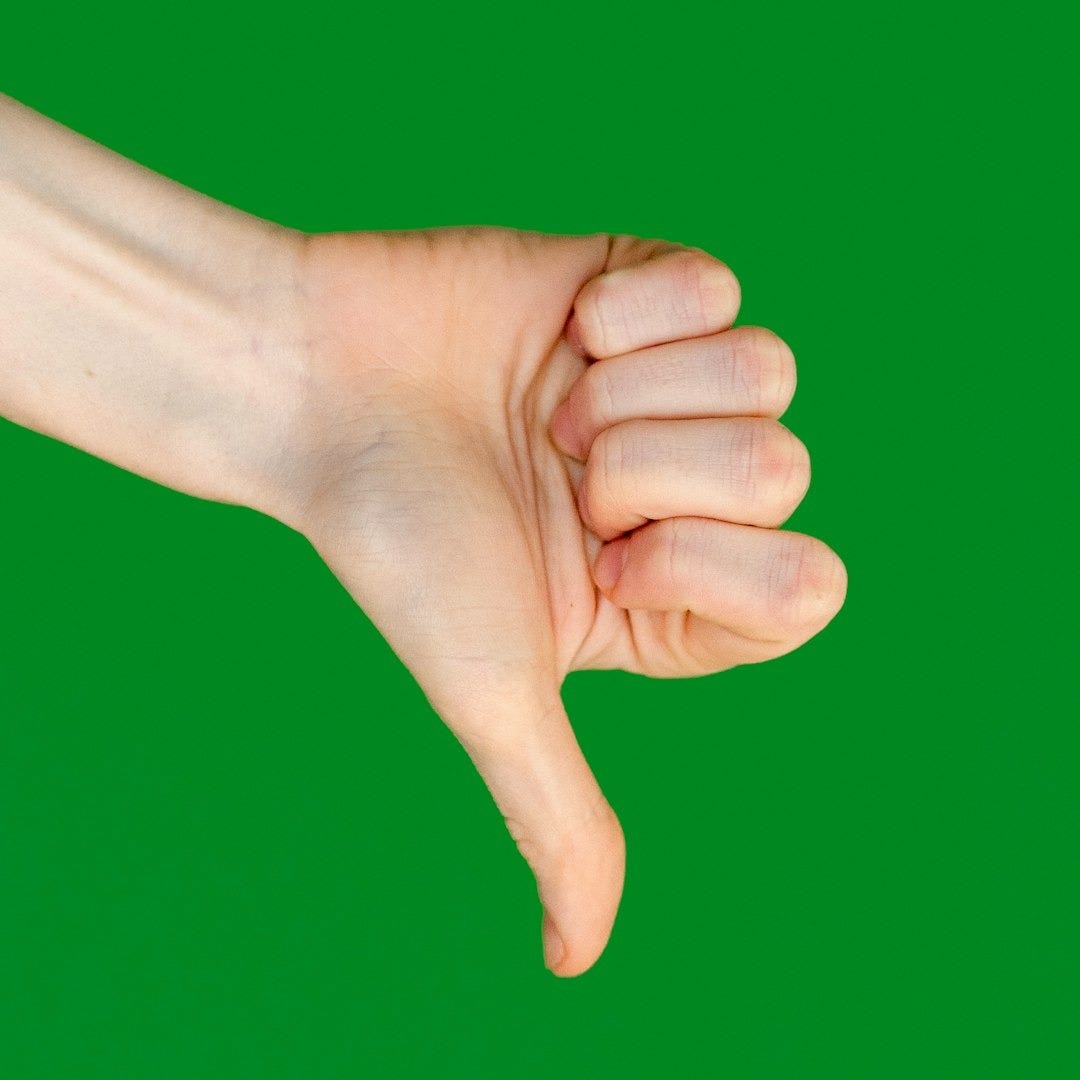 a person's hand holding a cell phone in front of a green background