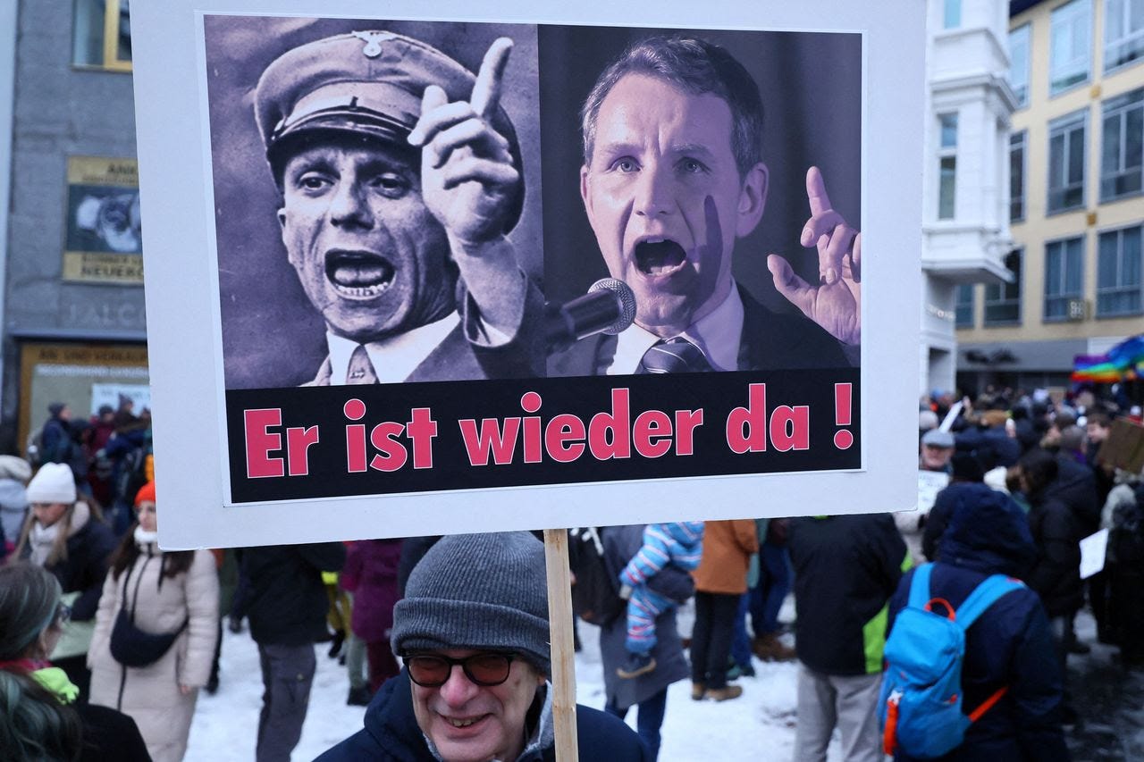 A protester holds a placard showing former Nazi propaganda minister Joseph Goebbels, left, and Bjoern Hoecke, the top candidate of the AfD in the upcoming federal state elections in Thuringia, on Sunday. (Wolfgang Rattay/Reuters)