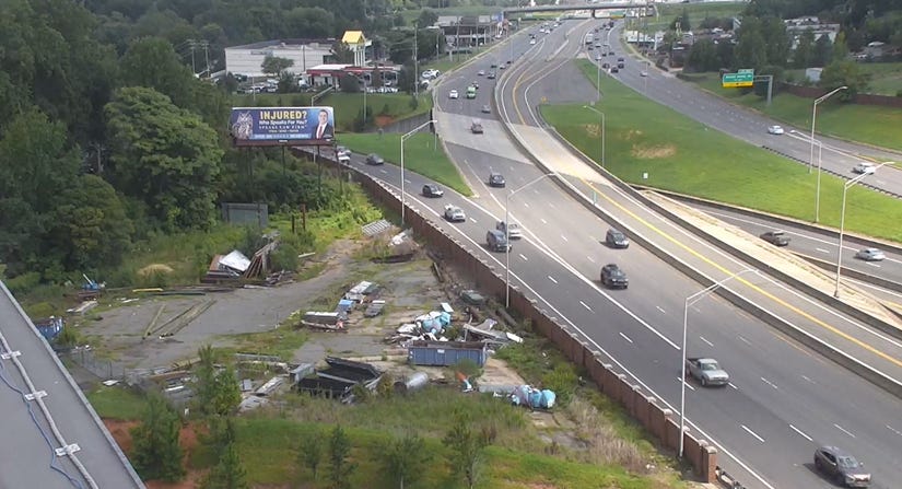 wider shot of highway with blue hugo statues next to it