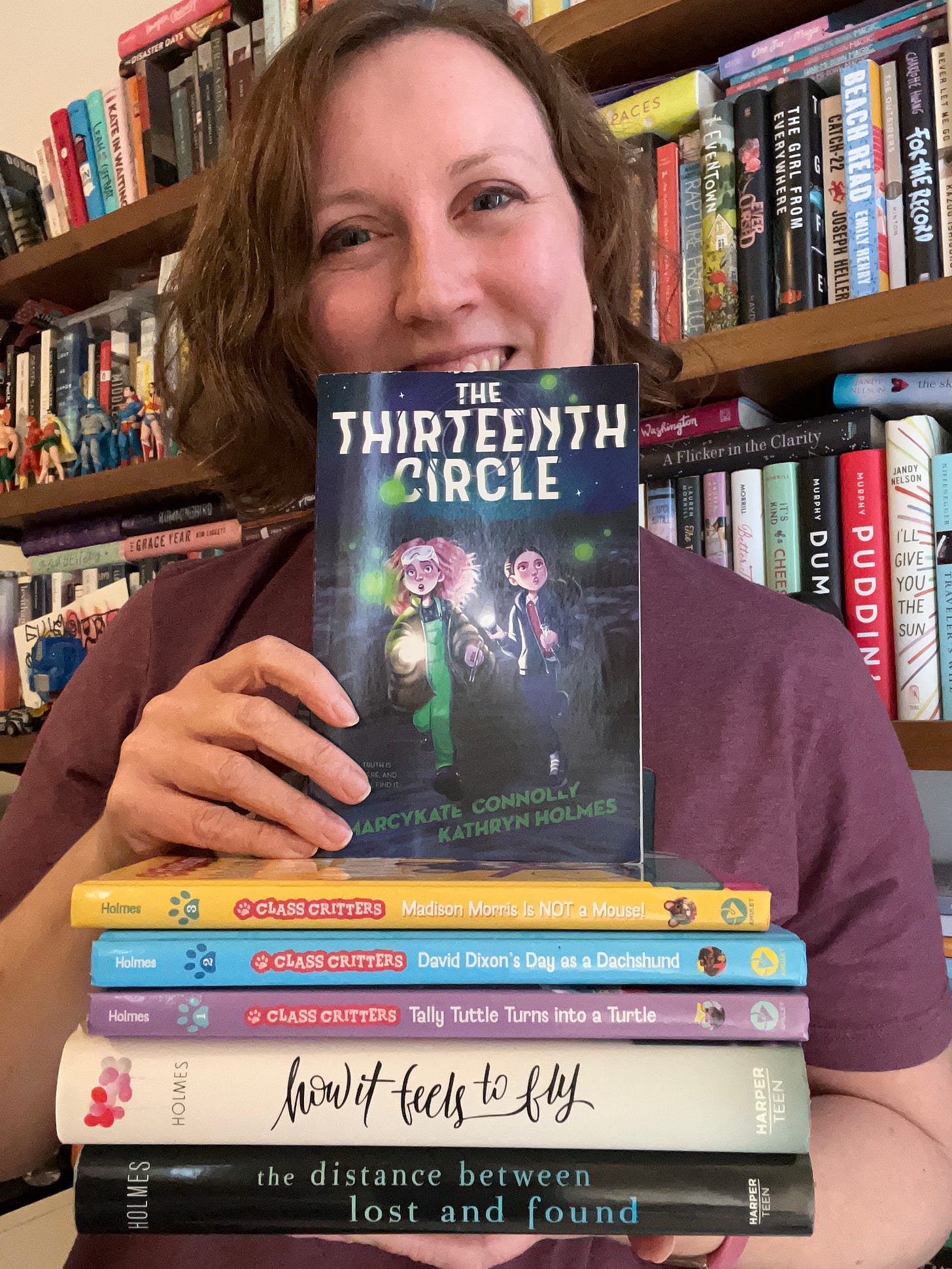 Kathryn poses with her six published books, The Thirteenth Circle at the top of the stack.