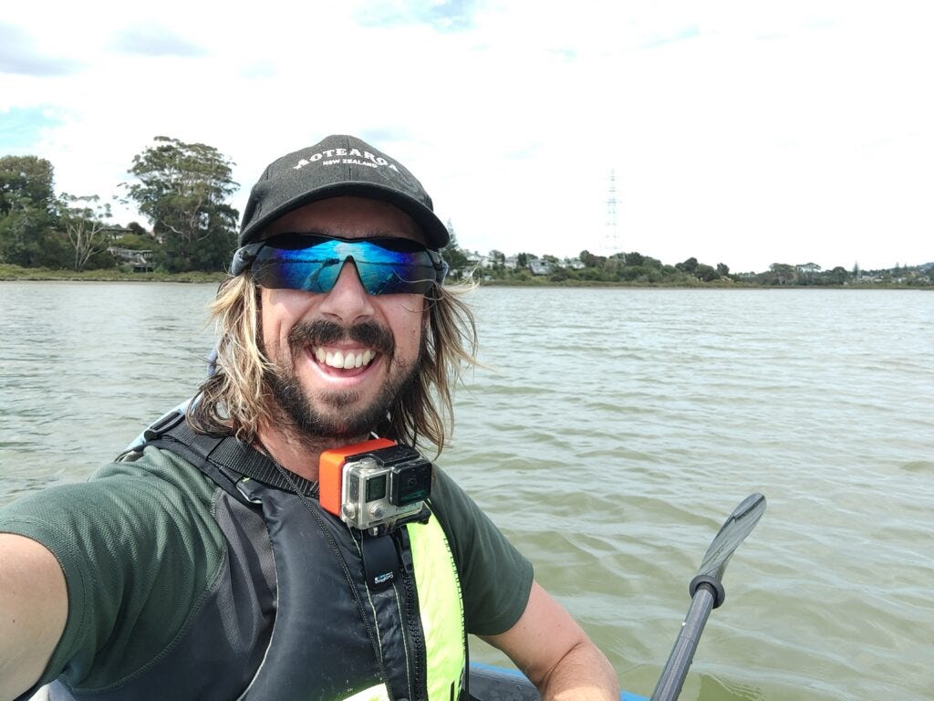 A scruffy-looking Dunc Wilson sits aboard his raft on the Whau River