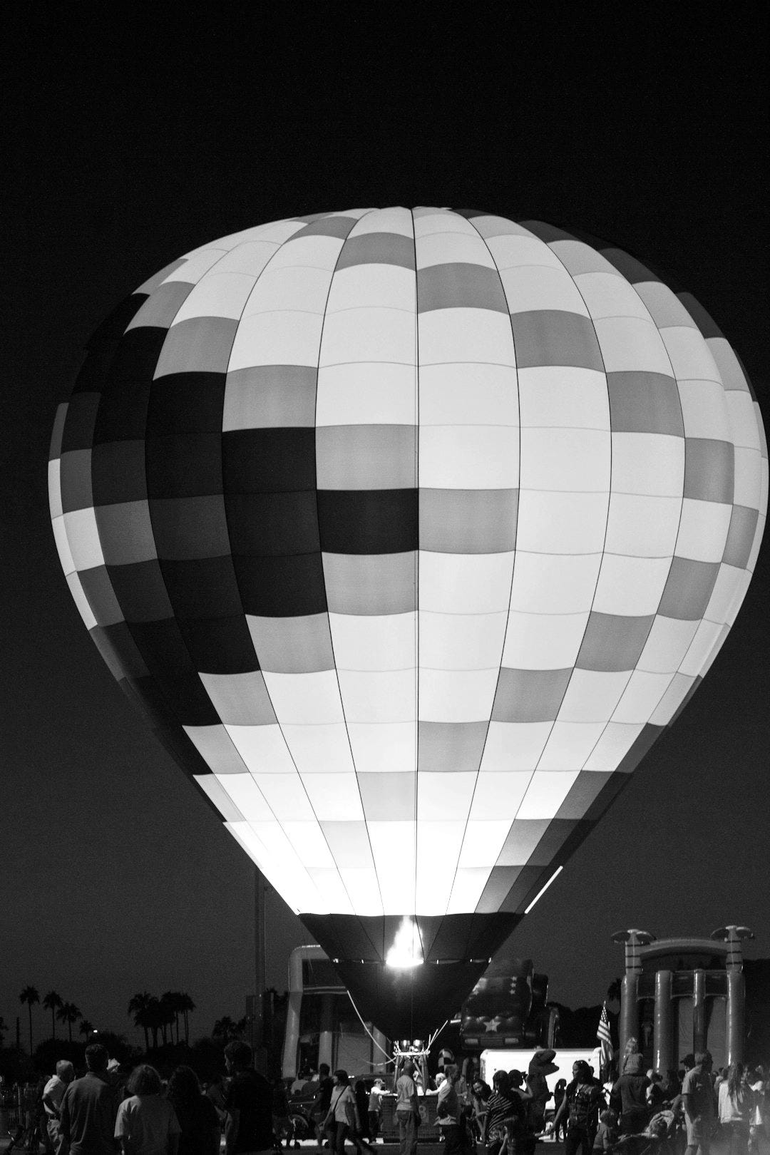 group of people in front of multicolored hot air balloon group of people in front of multicolored hot air balloon