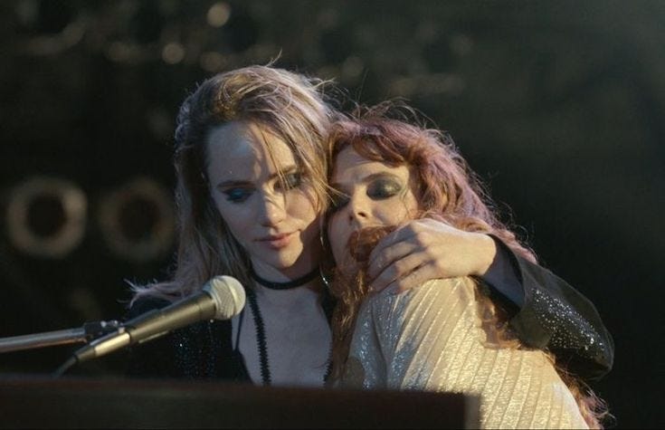 This may contain: two women hugging each other in front of a microphone