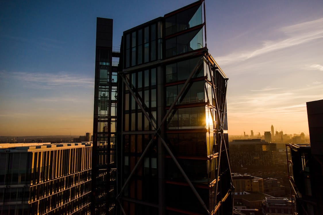 Free Exterior of contemporary glass skyscraper against sundown sky in city Stock Photo