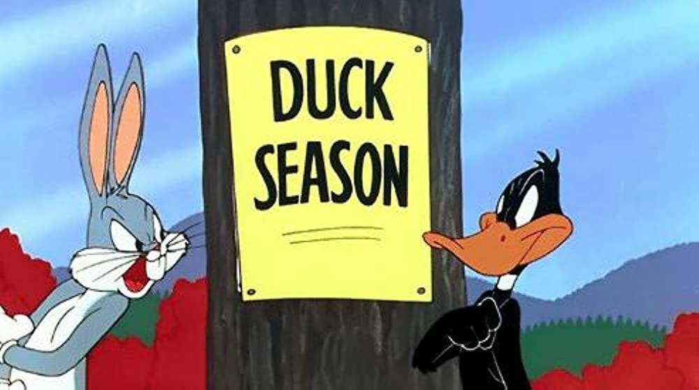 Bugs Bunny with Daffy Duck and a "Duck Season" sign on a tree.