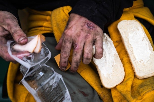 Sitting on a bus bench Elliot eats food he “boosted.”...
