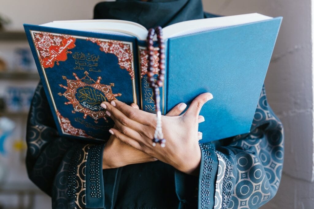 Person holding a blue religious book