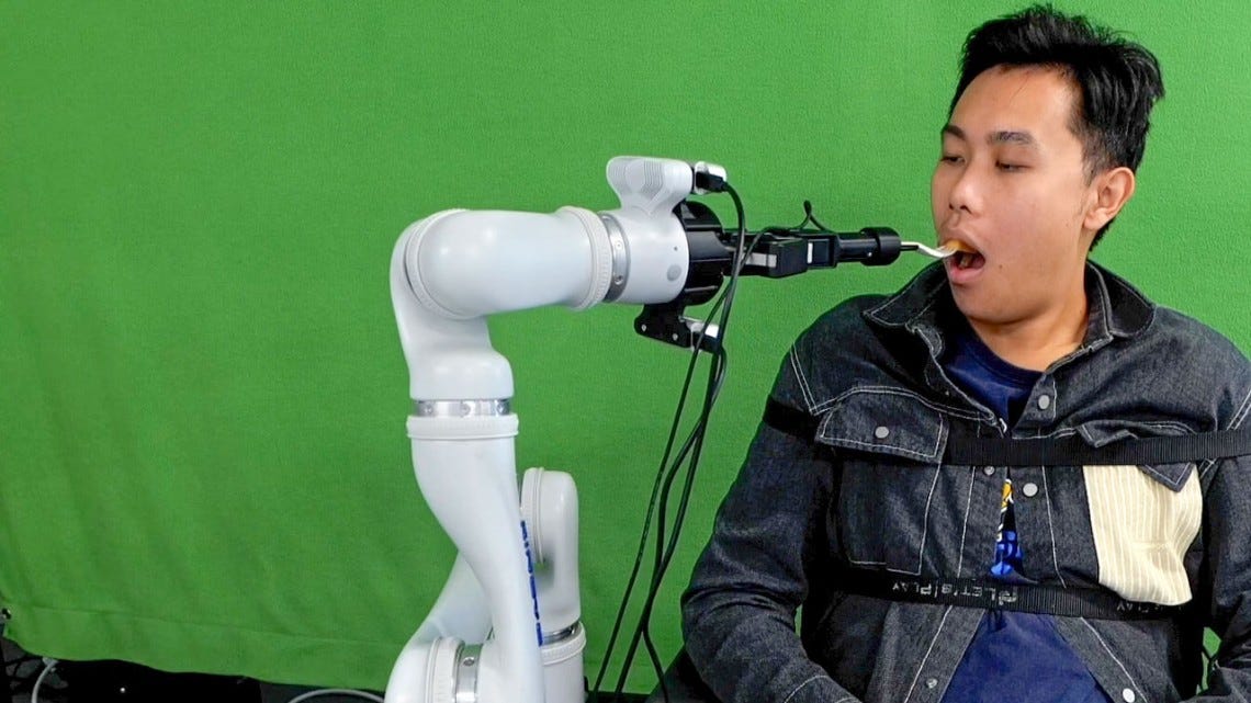 A robotic system developed by Cornell researchers feeds a student participant during a lab demonstration.