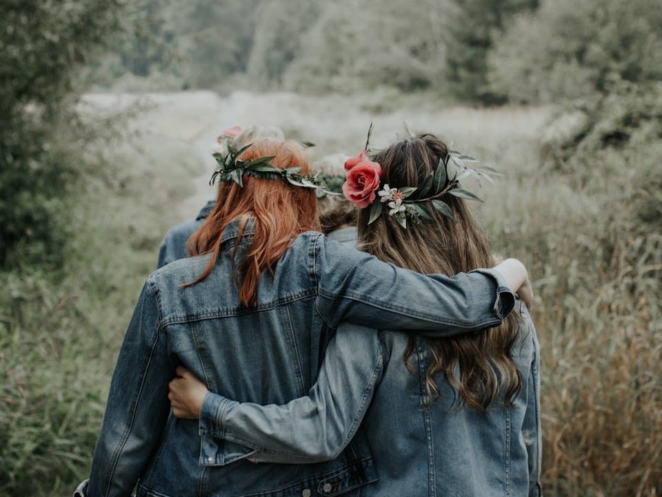 woman in blue denim jacket with red rose on ear