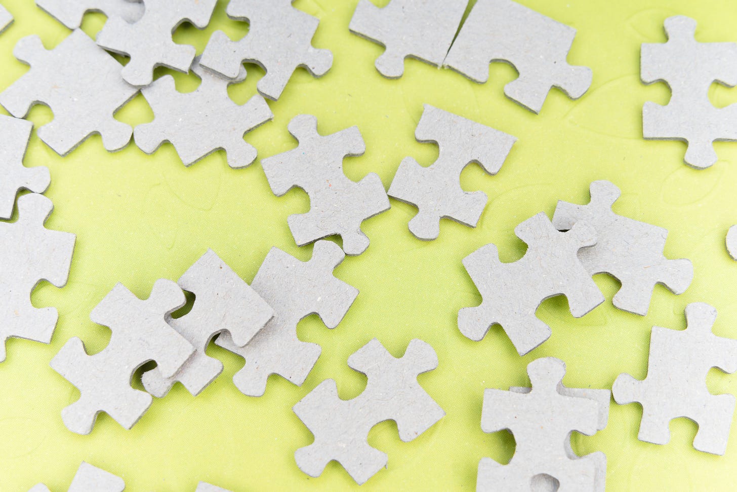 grey puzzle pieces on light green background
