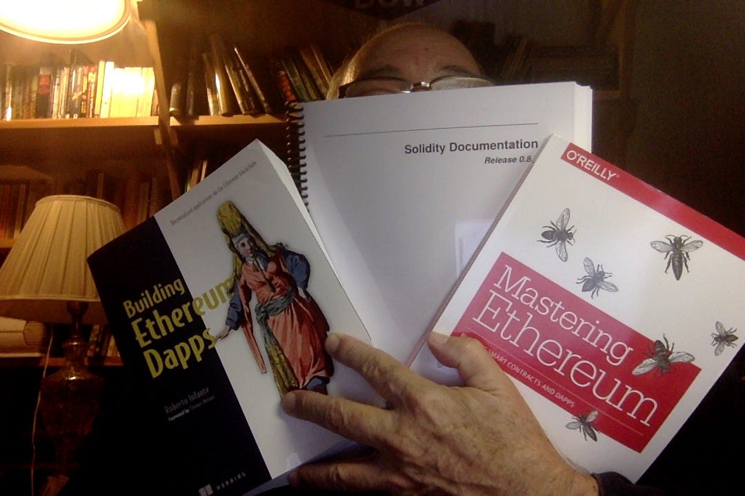  A photo of me holdingn 3 books about writing cryptocurrency 'smart contracts'. 