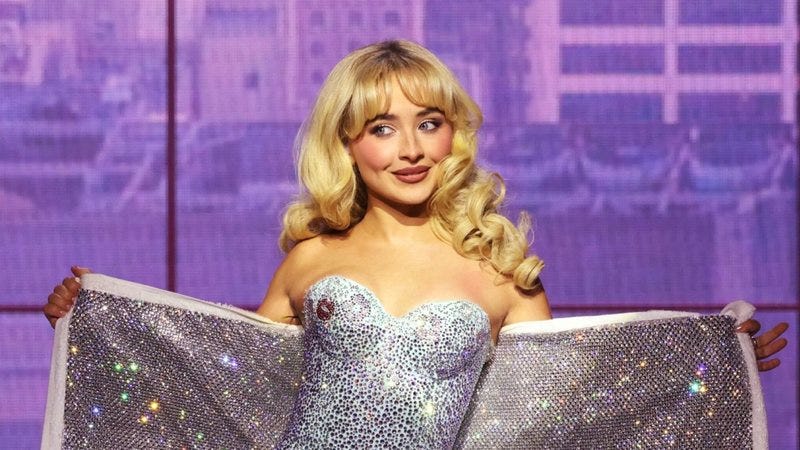 Foto de Sabrina Carpenter, uma cantora loira com um corselet prateado cheio de brilhos.