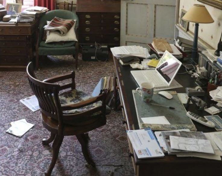 This may contain: an old fashioned desk is cluttered with papers