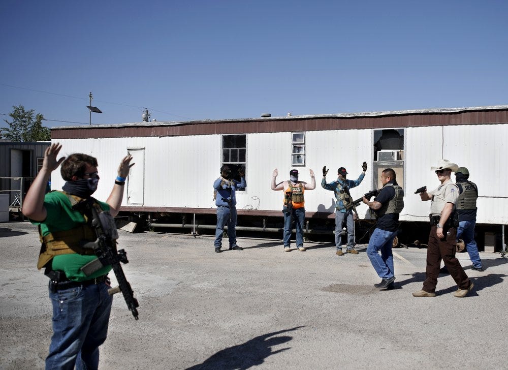 Deputies of the Ector County Sheriff's Office advance on protesters who gathered outside Big Daddy Zane's bar  Monday, May 4, 2020, in Odessa, Texas. Big Daddy Zane's opened Monday afternoon despite the Texas governor's orders prohibiting its operation until later in May. Armed protesters arrived to support the bar owner's decision, leading to arrest of eight individuals including the bar owner. (Eli Hartman/Odessa American via AP)