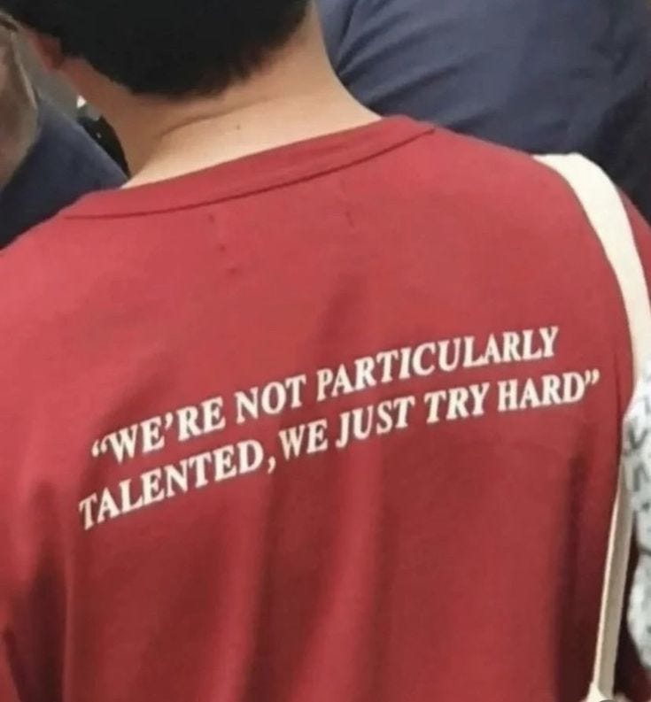 This may contain: the back of a man wearing a red shirt with white writing on it that says we're not particularly talented, we just try hard