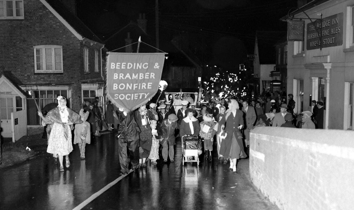 Black and white image of people in a procession, carrying a banner saying: "Beeding & Bramber Bonfire Society"
