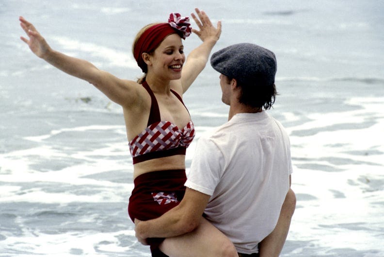 Rachel McAdams and Ryan Gosling are pictured in a still from The Notebook. Ryan holds Rachel in the ocean.