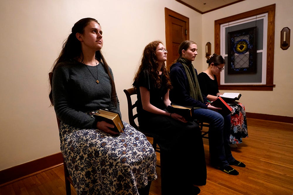 Benedictine College students, from left, Madeline Hays, Niki Wood, Ashley Lestone and Hannah Moore gather for evening prayers in a room which they converted to a chapel in the house they share Dec. 3, 2023, in Atchison, Kansas. (AP/Charlie Riedel)