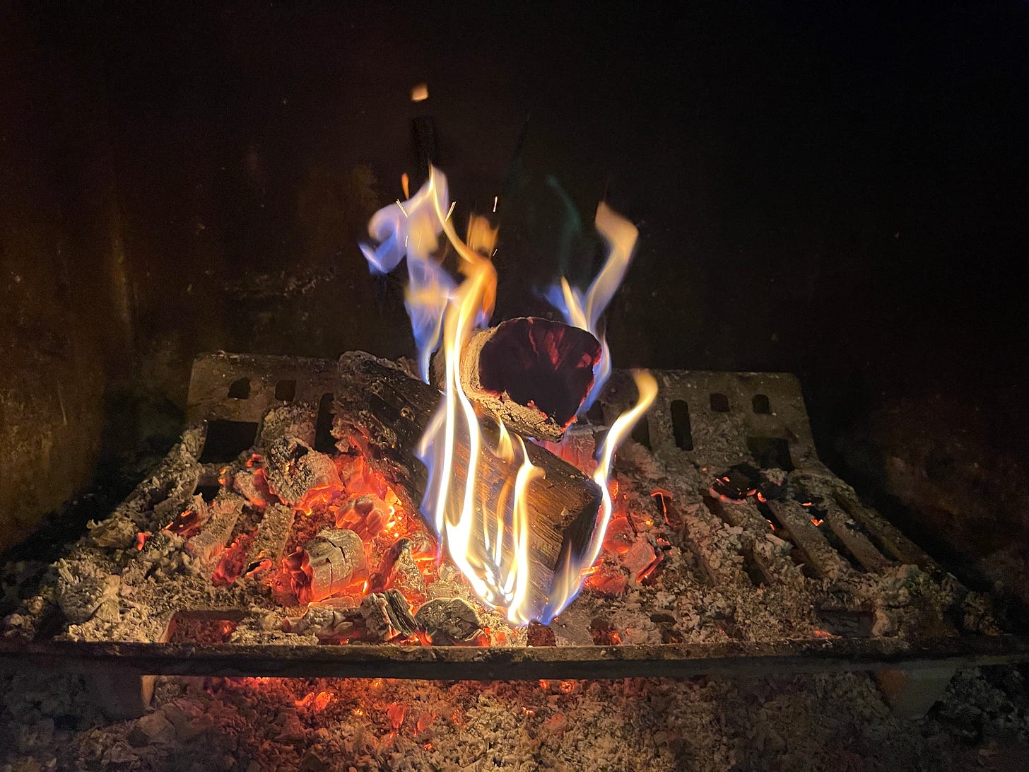 A log burns in a fireplace.